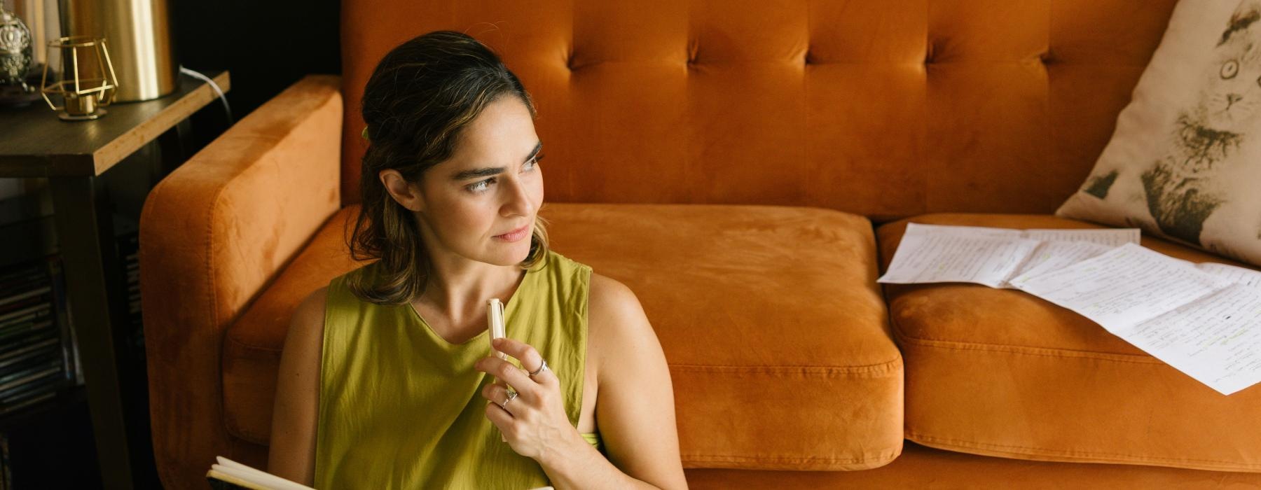 a person sitting next to a couch reading a book