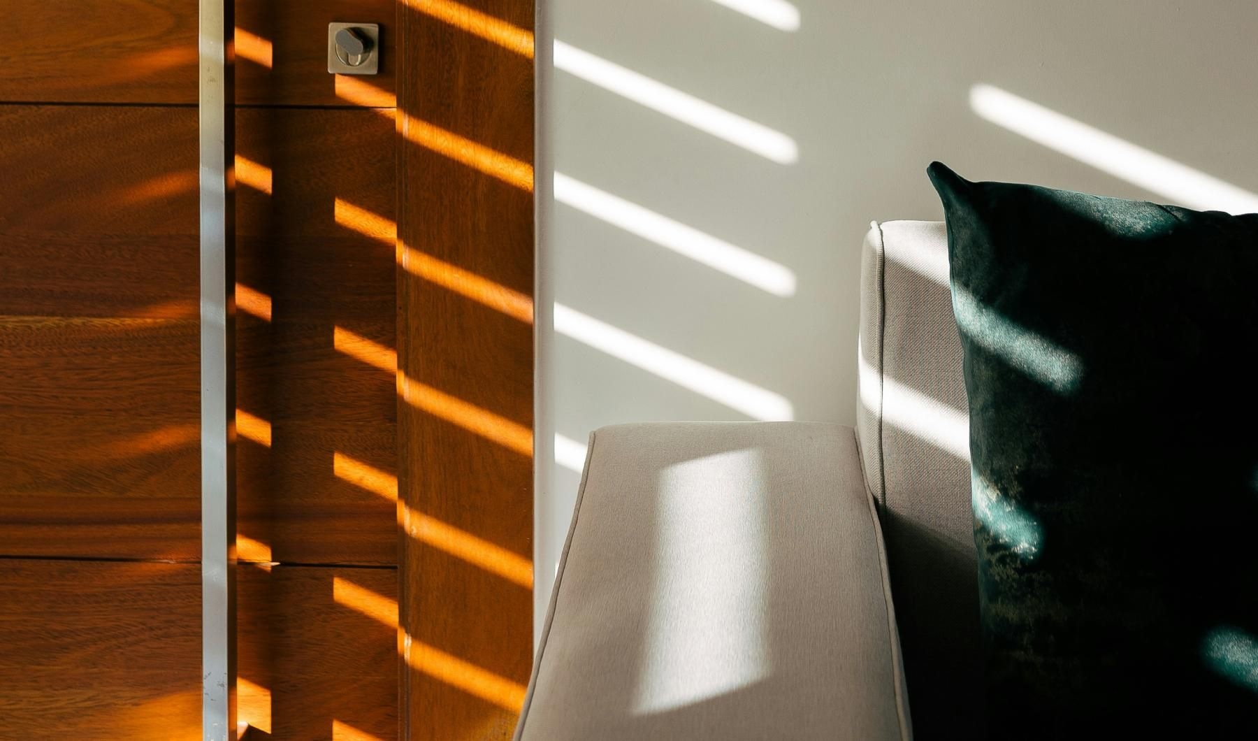 a chair with pillow next to a wall