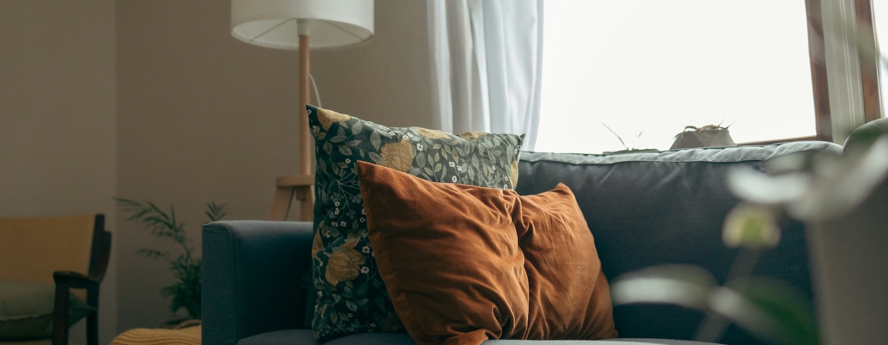 a couch with pillows and a lamp