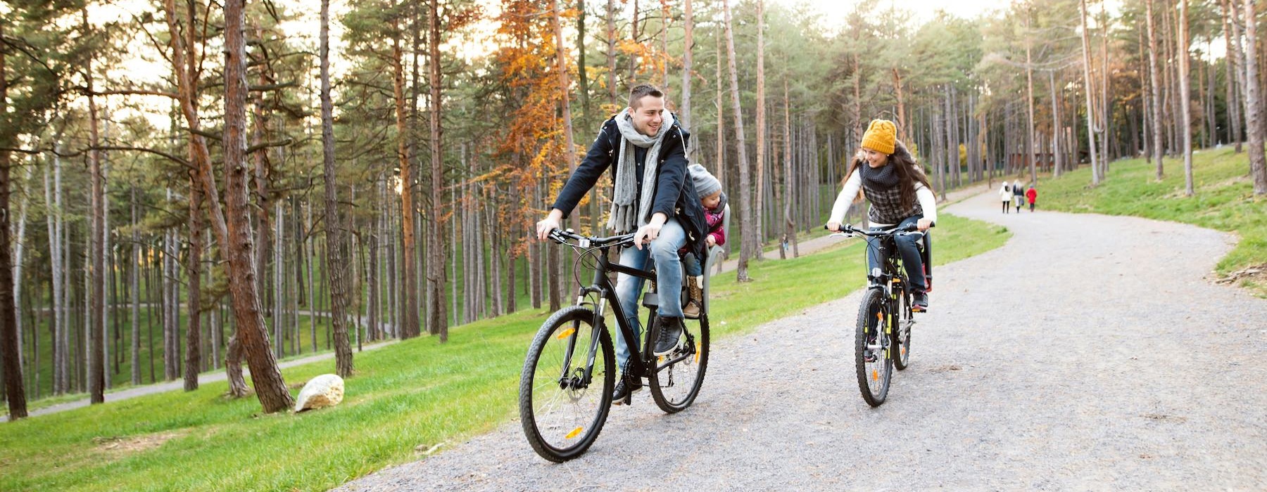 a man and a woman riding bikes on a path in the woods