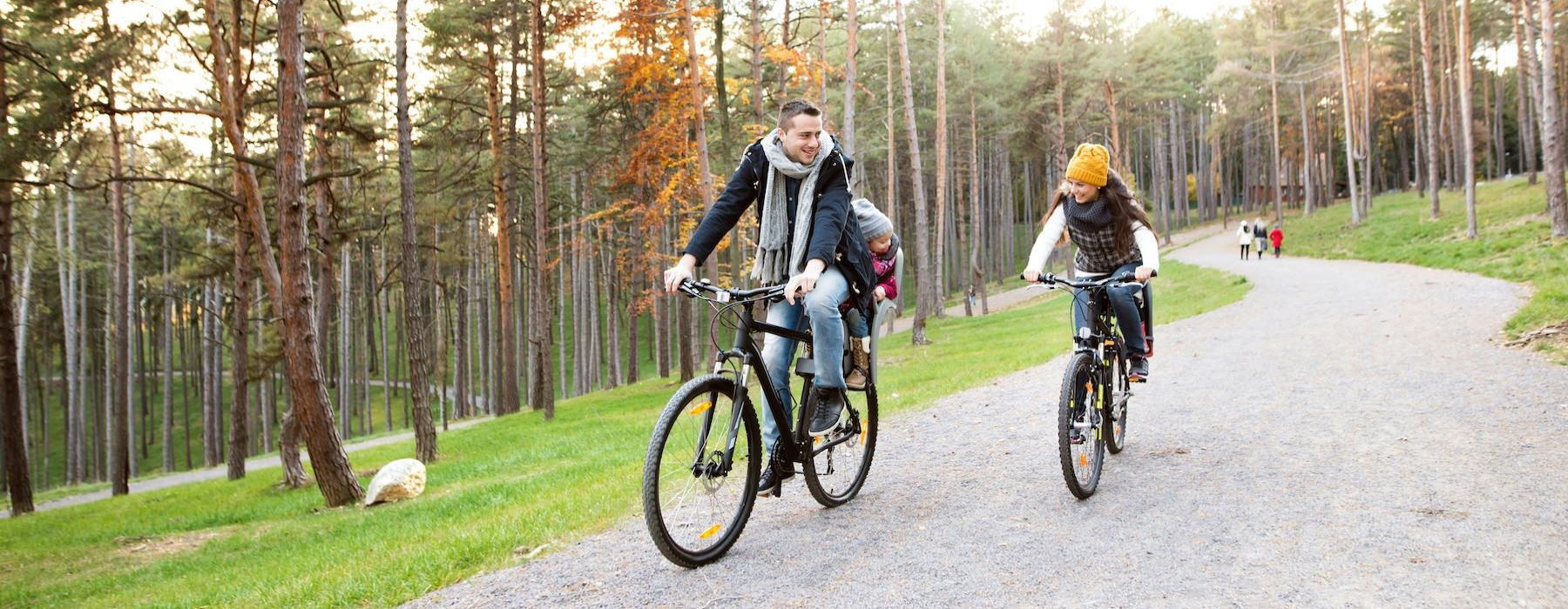 a man and a woman riding bikes on a path in the woods