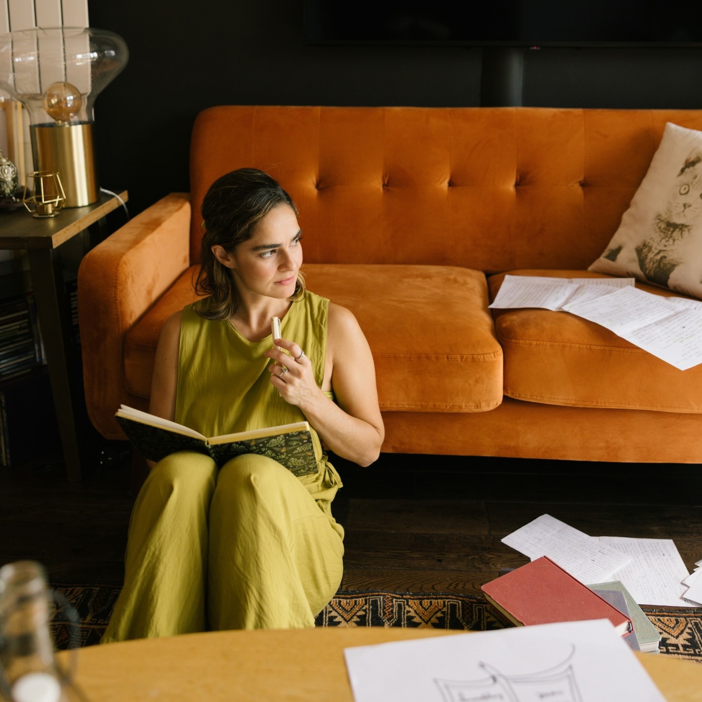 a person sitting next to a couch reading a book