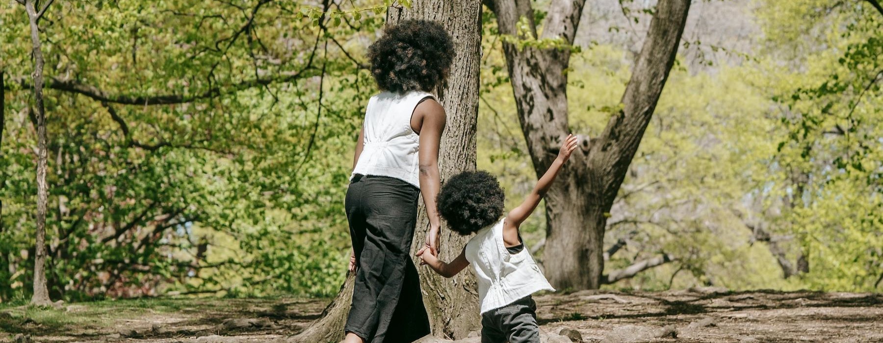 a person and a child playing in a forest