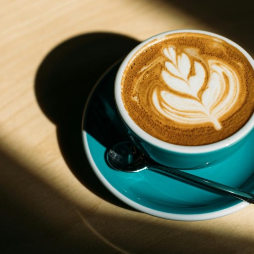 a cup of coffee with a design on the foam